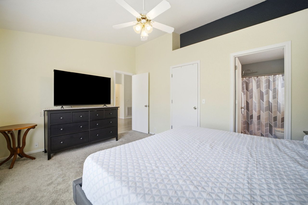 Primary Bedroom with vaulted ceilings, shelf area, looking out to closet, ensuite bath and main living area