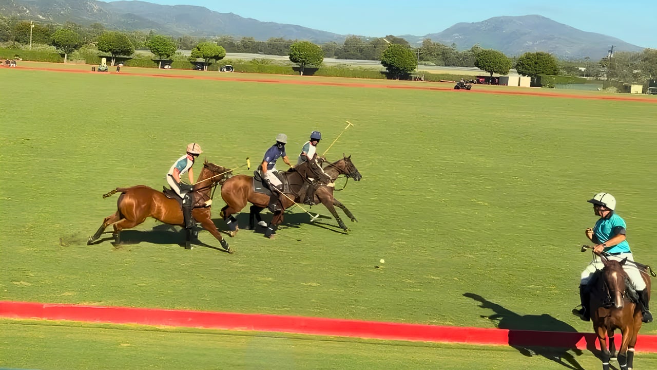 Three polo players on horseback race across the field at Santa Barbara Polo & Racquet Club, with foothills and open farmland in the background.