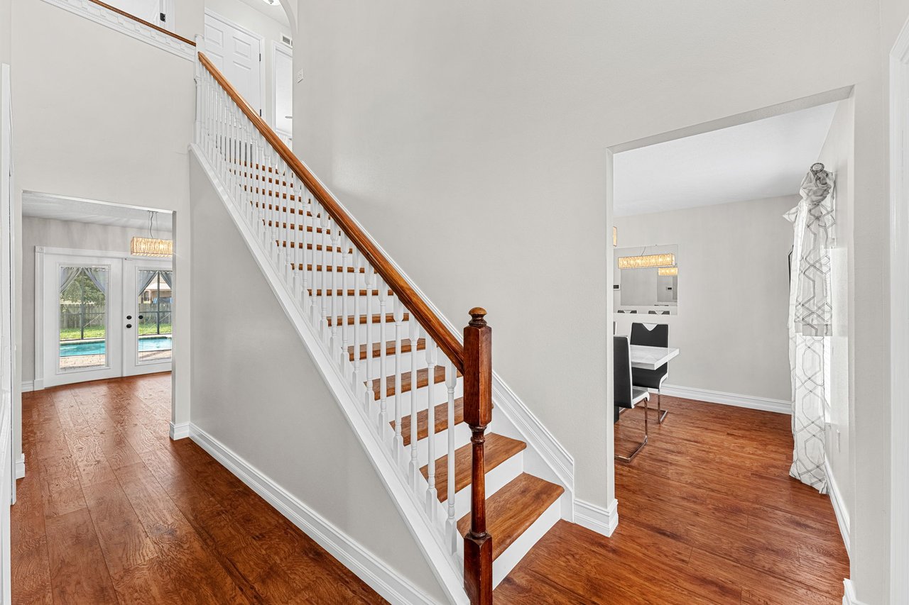 Open staircase and foyer with wood-look flooring