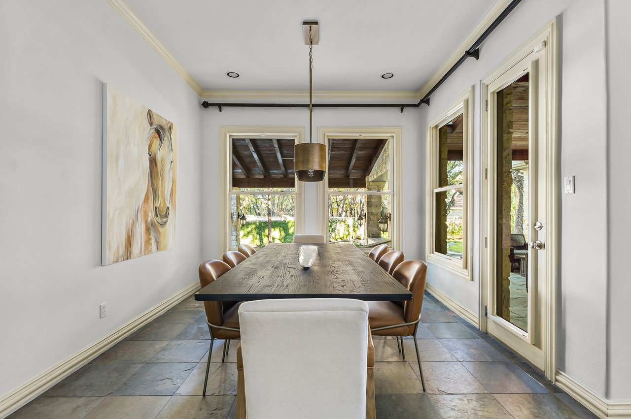 Breakfast nook with wood table and French doors overlooking the patio at 5902 Saratoga Cove, Davenport Ranch, Austin, Texas.