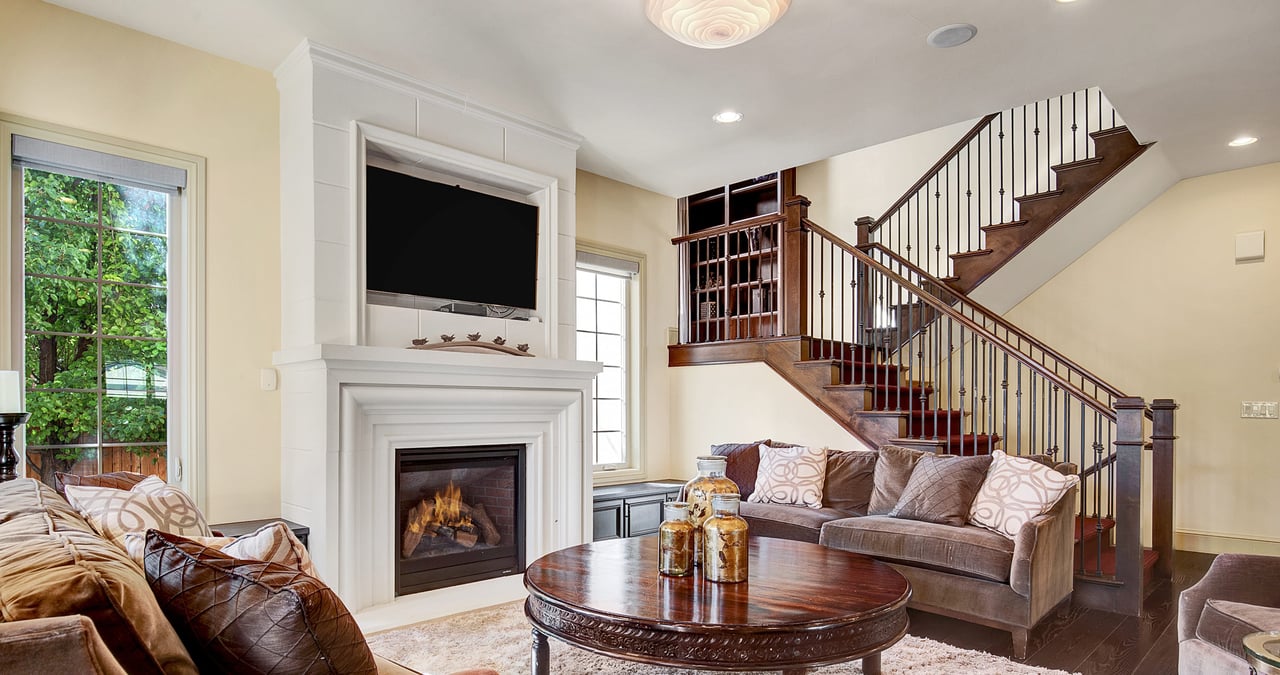 Living room with fireplace, couch, coffee table, TV on the wall