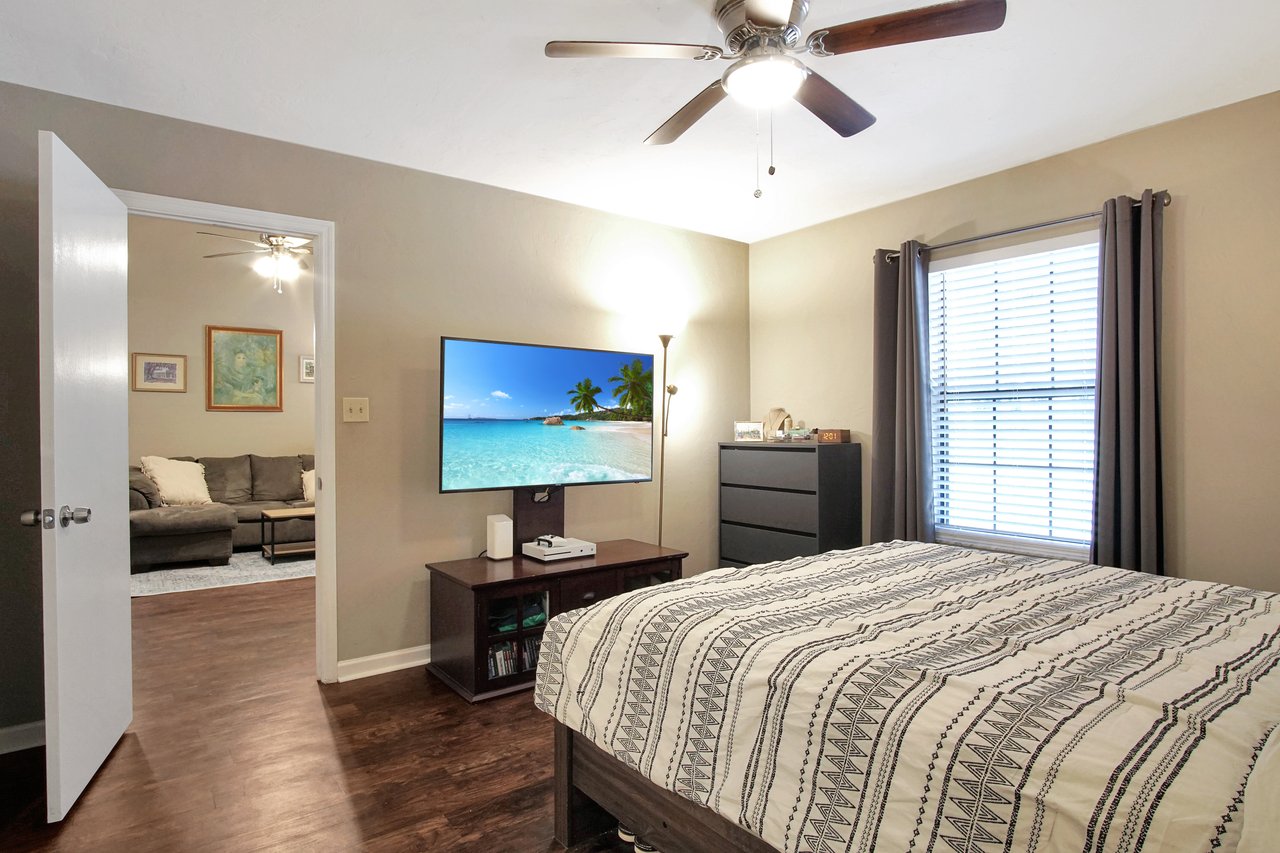 A cozy bedroom featuring a bed, a dresser, and a television for relaxation and comfort.