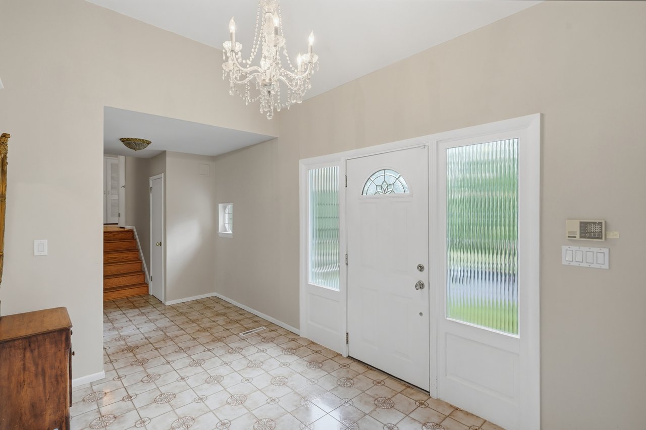 Welcoming entrance featured by classic tile and chandelier