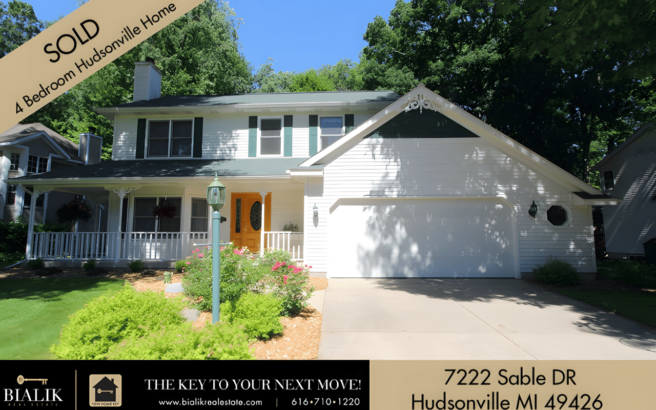 White two-story Hudsonville home with an attached garage, orange front door, and SOLD banner.