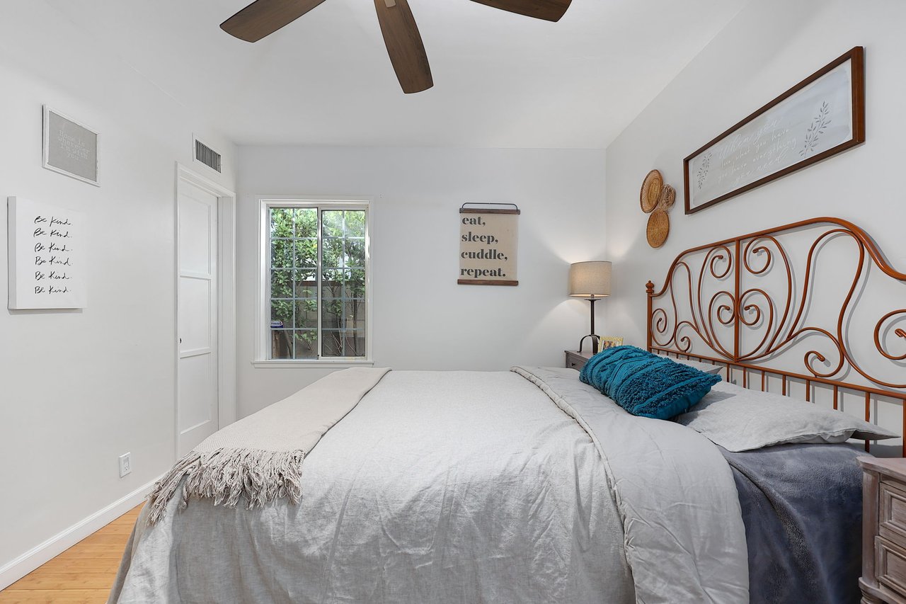 Cozy Lake Balboa primary bedroom with decorative wall art and large window overlooking yard