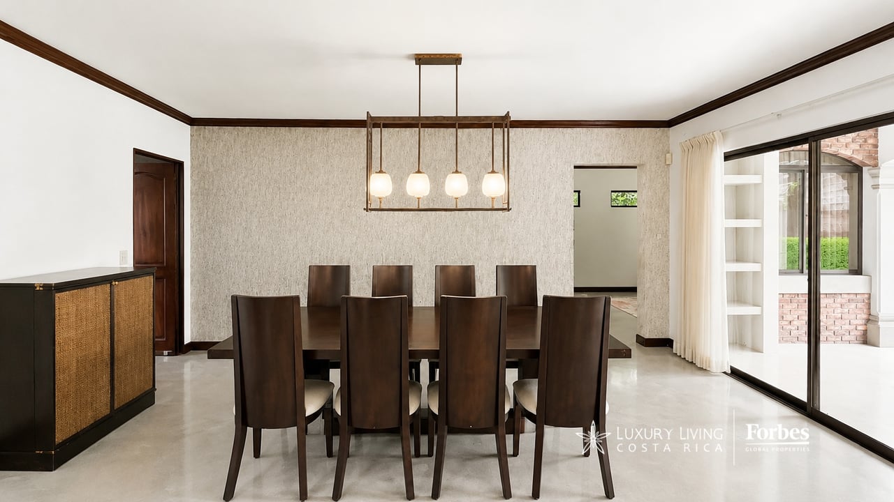 Dining room with dark wood furniture, a four-light pendant, and sliding doors to the patio.