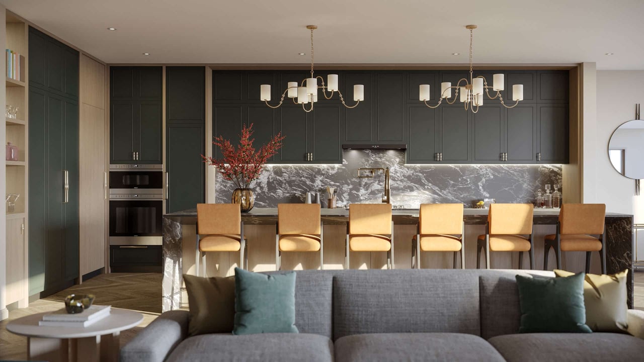 Open-plan kitchen with dark cabinetry, a veined stone island, brass pendants, and a gray sofa.
