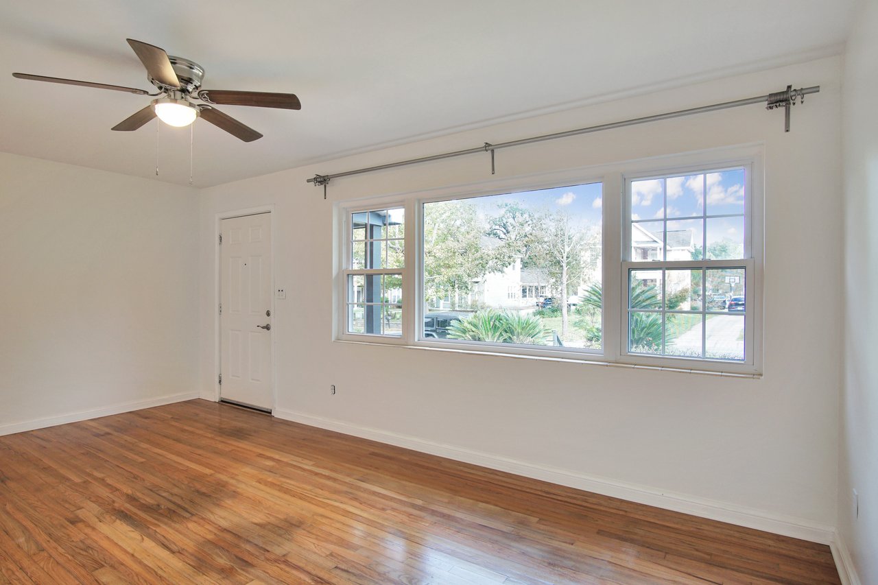 Empty utility storage room featuring hardwood floors and a ceiling fan, creating a spacious and airy atmosphere.