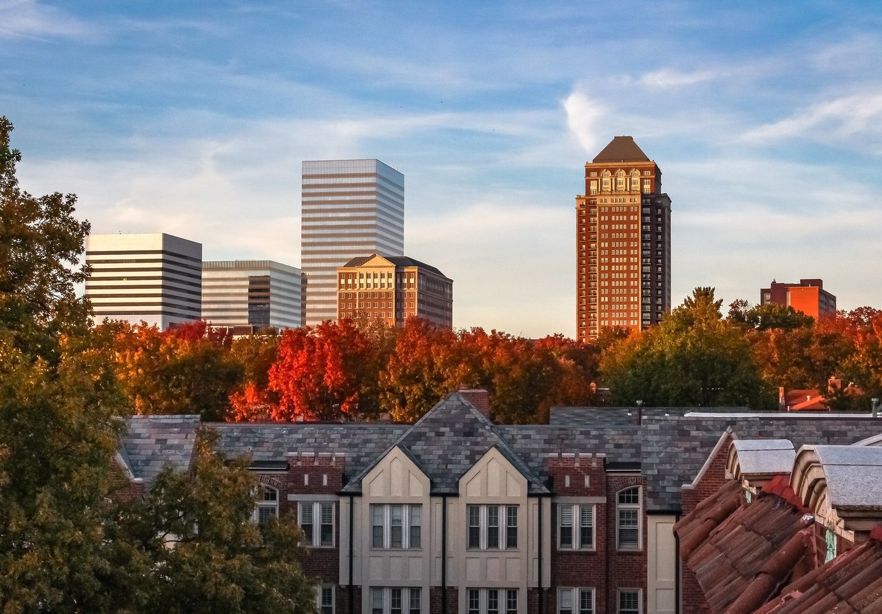 Clayton skyline above autumn trees and residential rooftops.