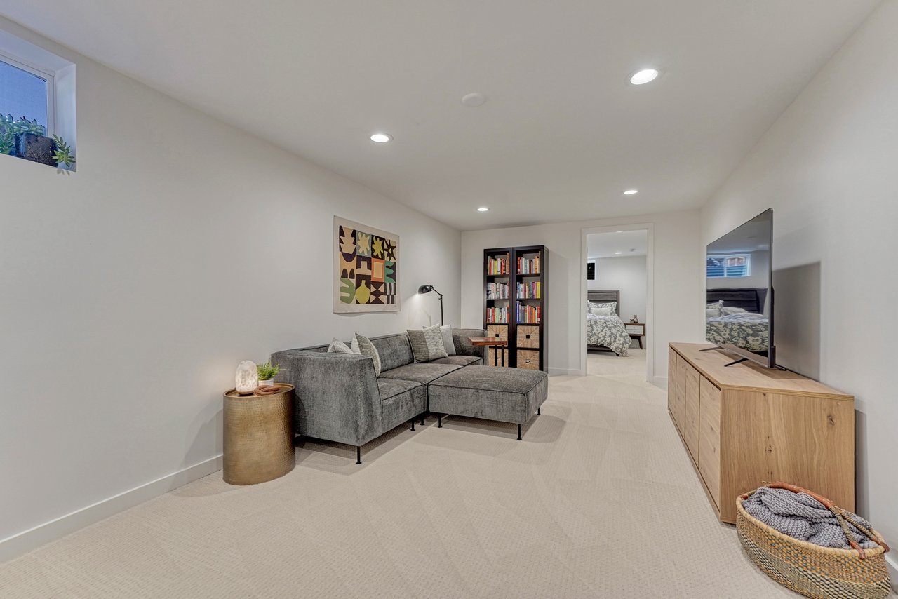 Lower-level family room with carpet and recessed lighting, looking toward the bedroom
