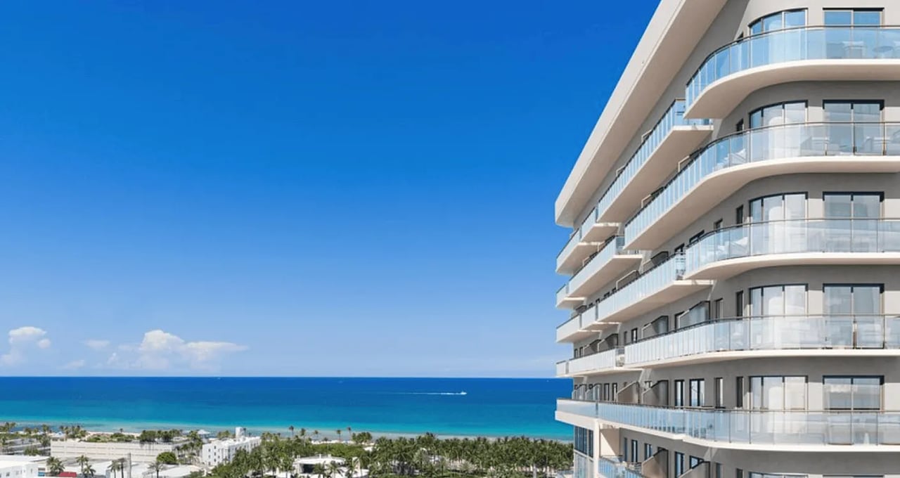 Modern condominium balconies overlooking a tropical beach and ocean.