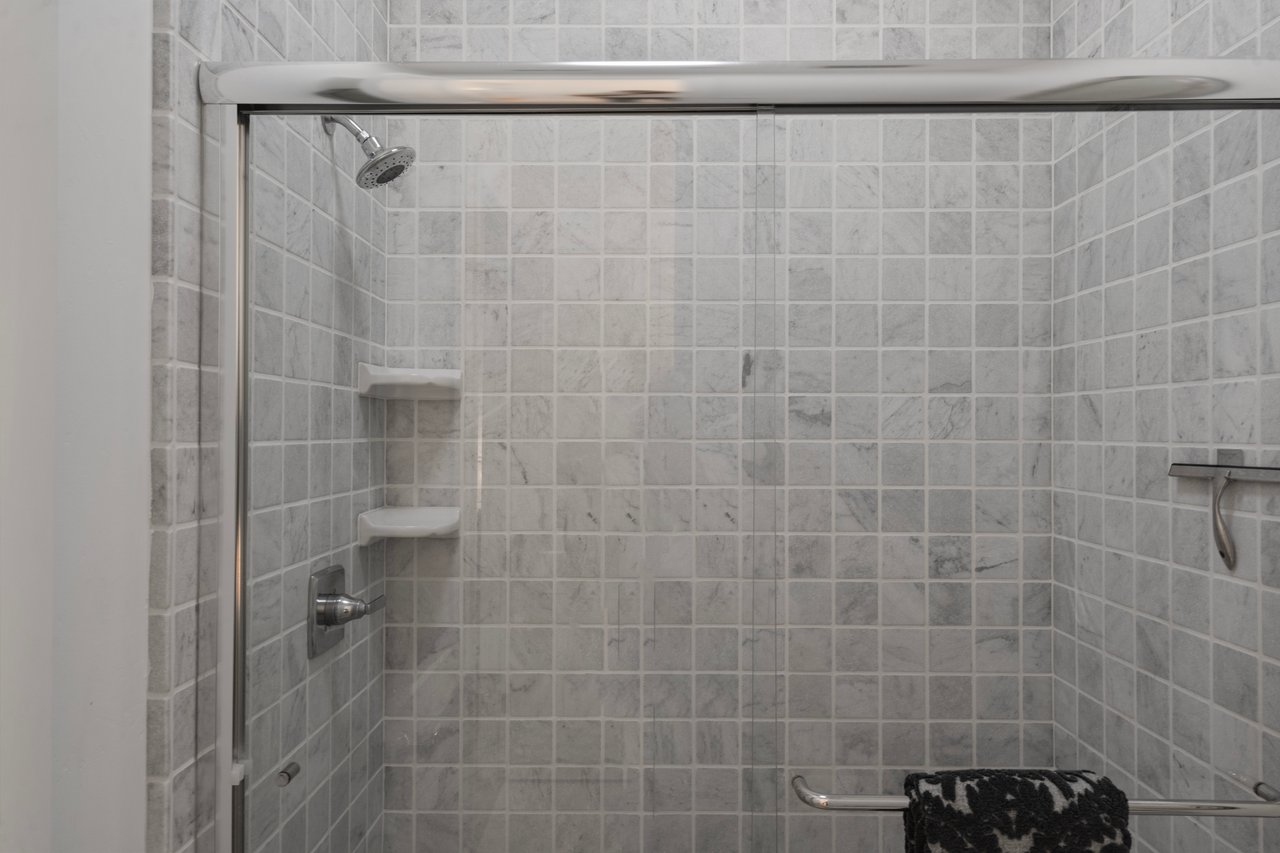 Bathroom with tumbled Carrara marble and warm, classic details