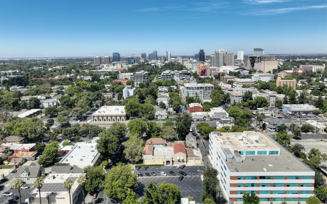 Aerial view of Phoenix skyline beyond leafy residential and commercial blocks.