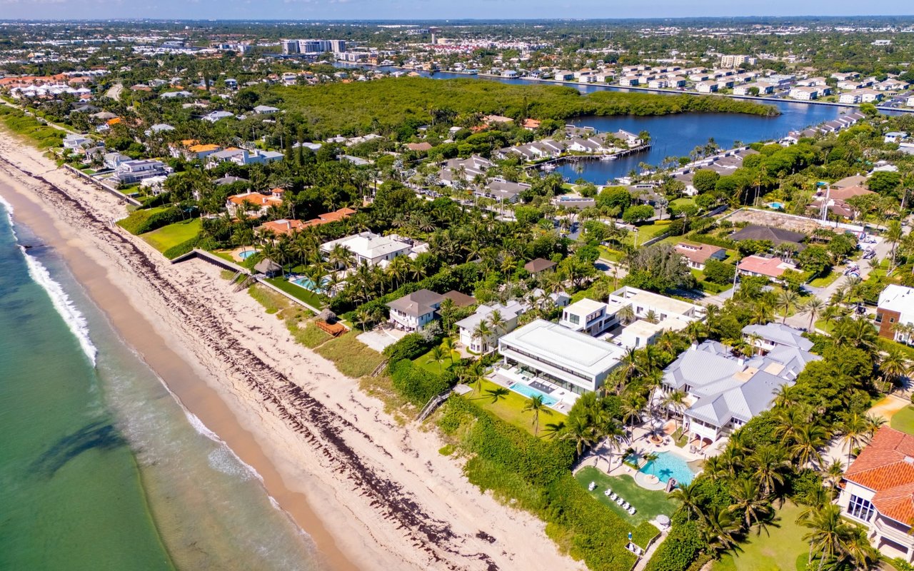 Aerial view of Ocean Ridge beachfront homes, sandy shoreline, and waterfront canals.