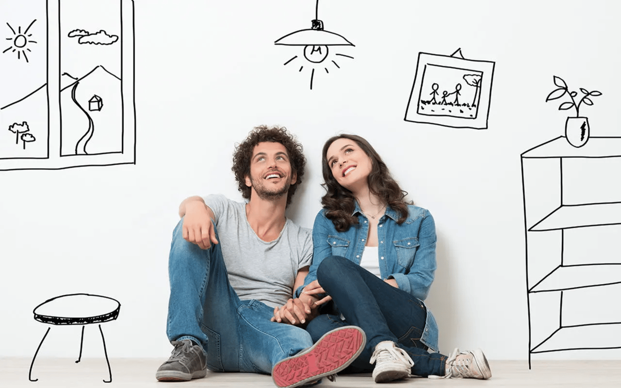 A smiling couple sits beneath hand-drawn home and furnishings, imagining a future home.