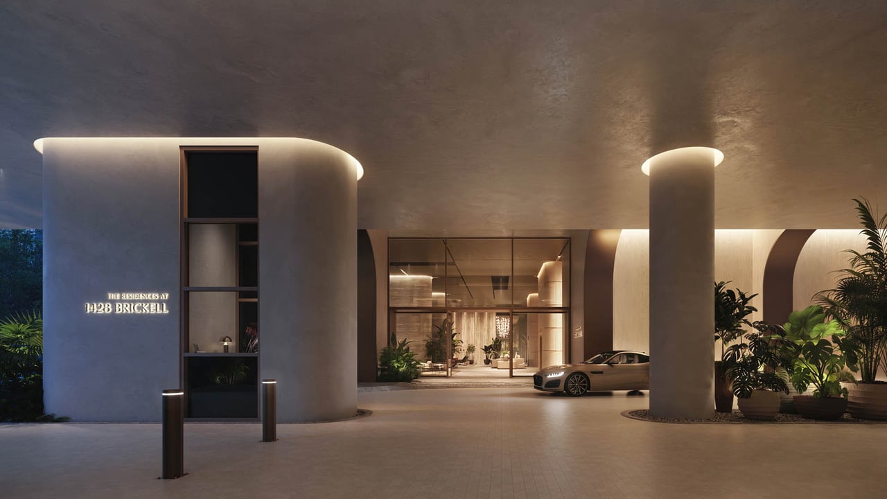 1428 Brickell Residences entrance with illuminated signage, glass lobby, and covered vehicle drop-off.