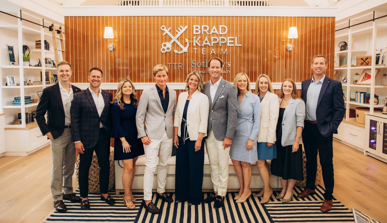 The Brad Kappel Team at TTR Sotheby's International Realty standing in their West Annapolis office at 103 Annapolis Street, Annapolis, Maryland, celebrating their #1 Maryland and #22 national ranking in the 2026 RealTrends Verified + The Thousand rankings. Maryland's number one waterfront real estate team serving Annapolis, Anne Arundel County, the Chesapeake Bay, and the Eastern Shore.