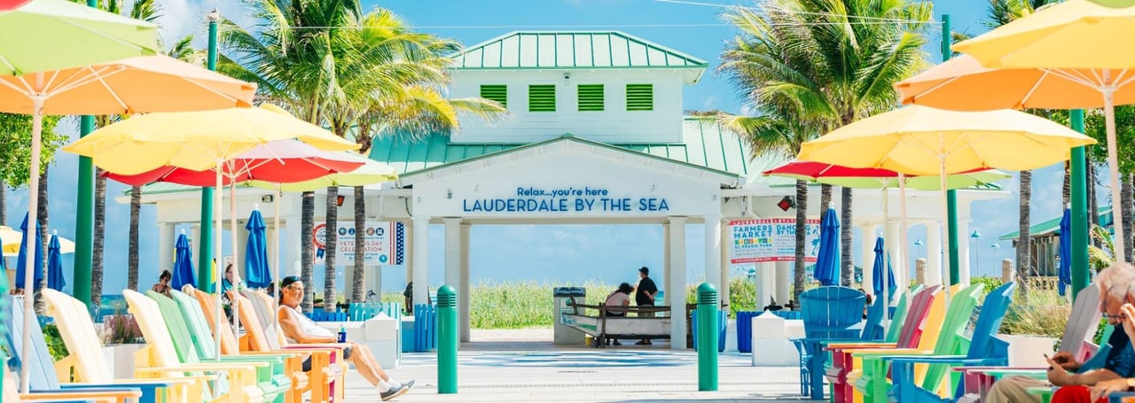 Beach pavilion entrance with colorful chairs and umbrellas in Lauderdale-by-the-Sea, Florida.