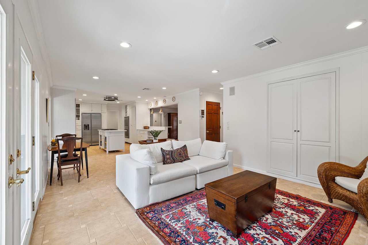 Open kitchen and living area with tile floors and a stainless refrigerator, Tarrytown, Austin.