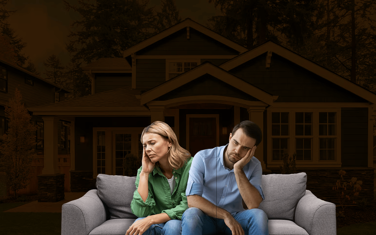 Concerned couple sitting apart on a sofa in front of a house
