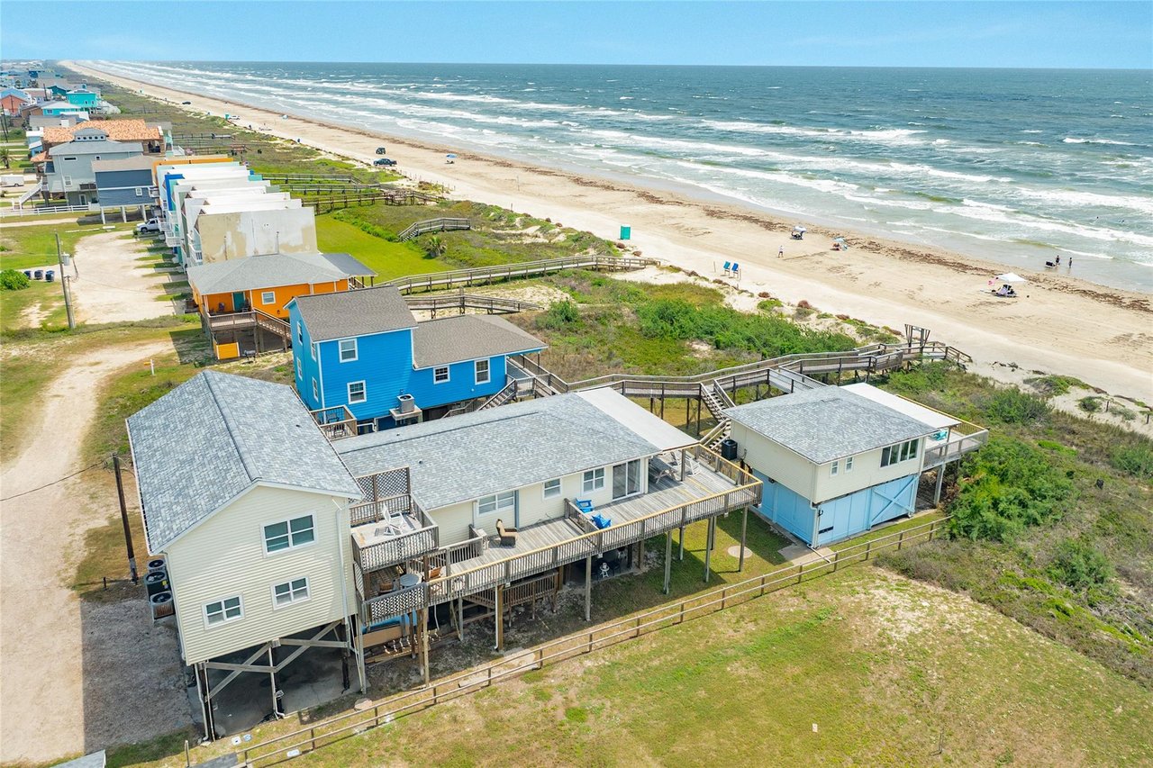 Four-unit beachfront investment property in Surfside Beach, TX. 9 bed / 6.2 bath, direct beach access, Blue Gulf views. $949,000.
