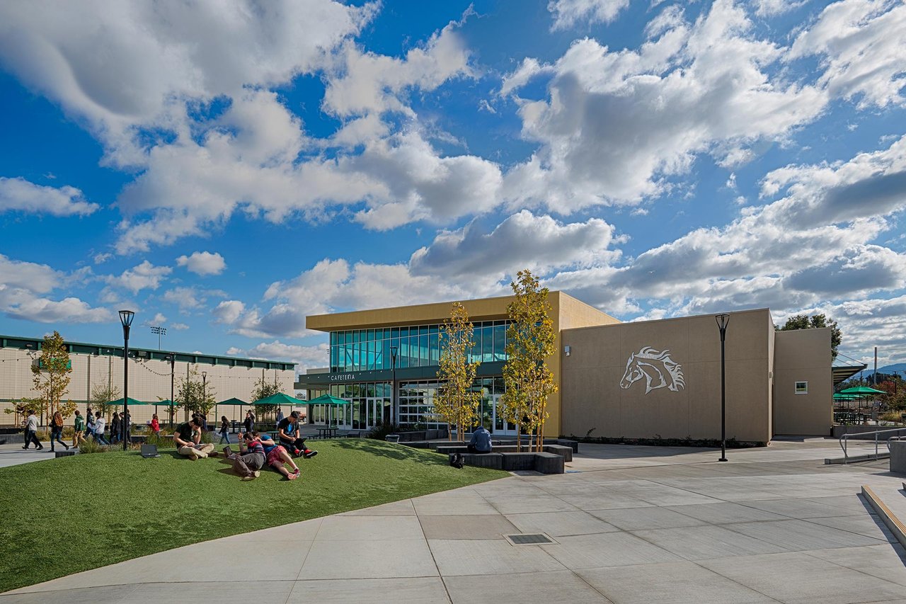 Homestead High School’s glass-fronted cafeteria and horse emblem overlook a student gathering lawn.
