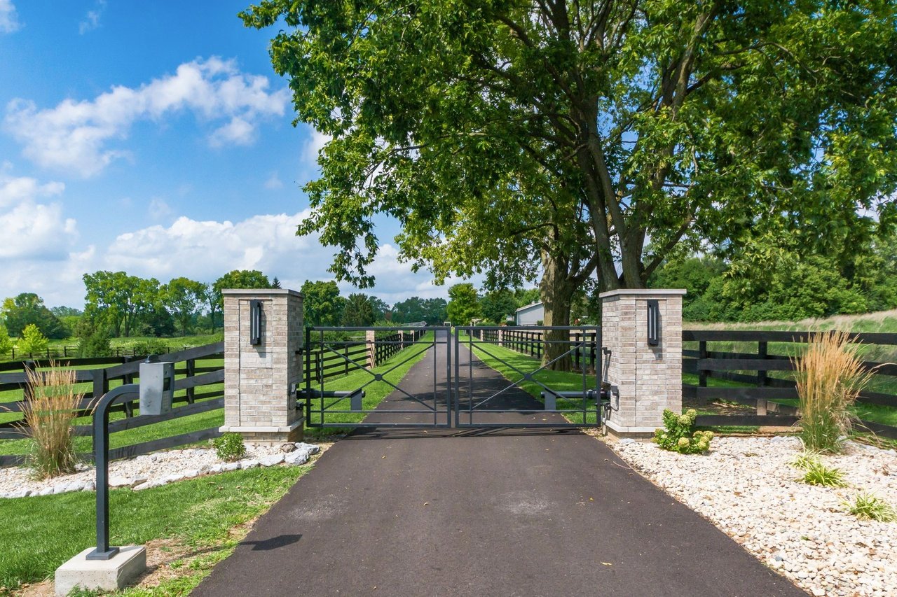 Gated entrance and tree-lined driveway leading to a private luxury estate in Central Ohio