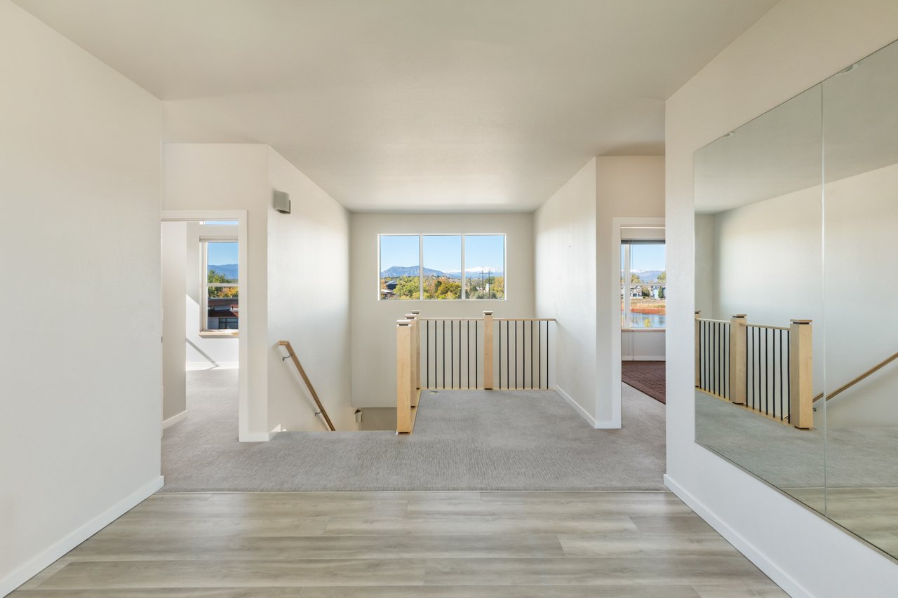 Loft looking toward the stair railing and a window with distant mountain views