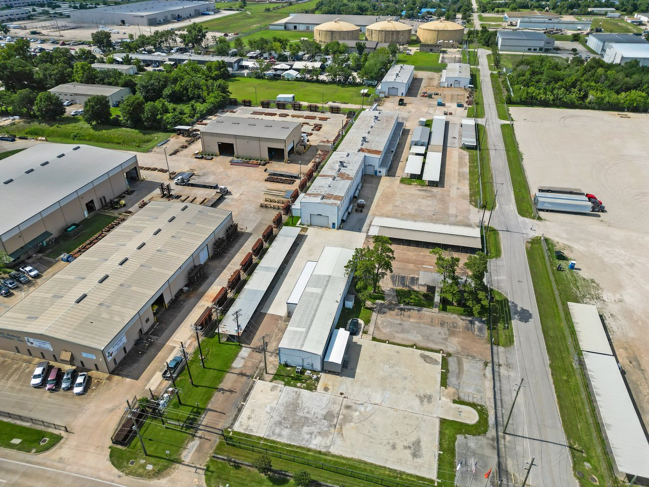Industrial warehouse complex with multiple buildings, loading yards, and an adjacent road.