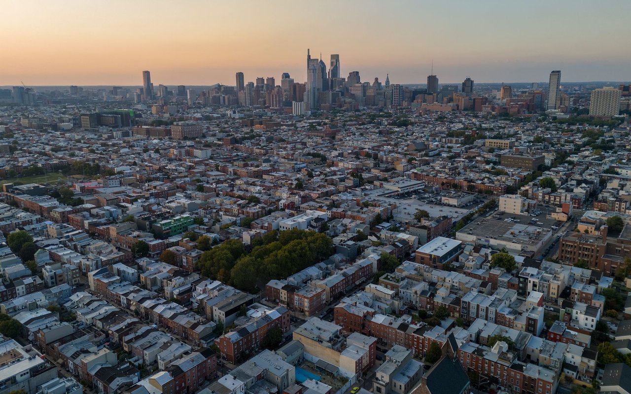 Philadelphia neighborhoods and the Center City skyline seen from above at sunset.