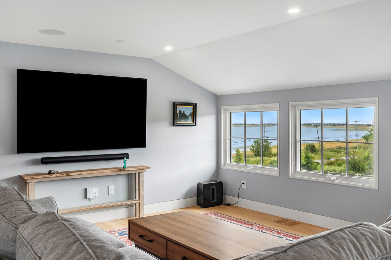 Living room with gray sofas and a wide water view through two windows.