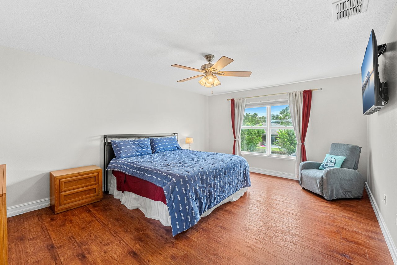 Upstairs primary suite with wood-look flooring and natural light