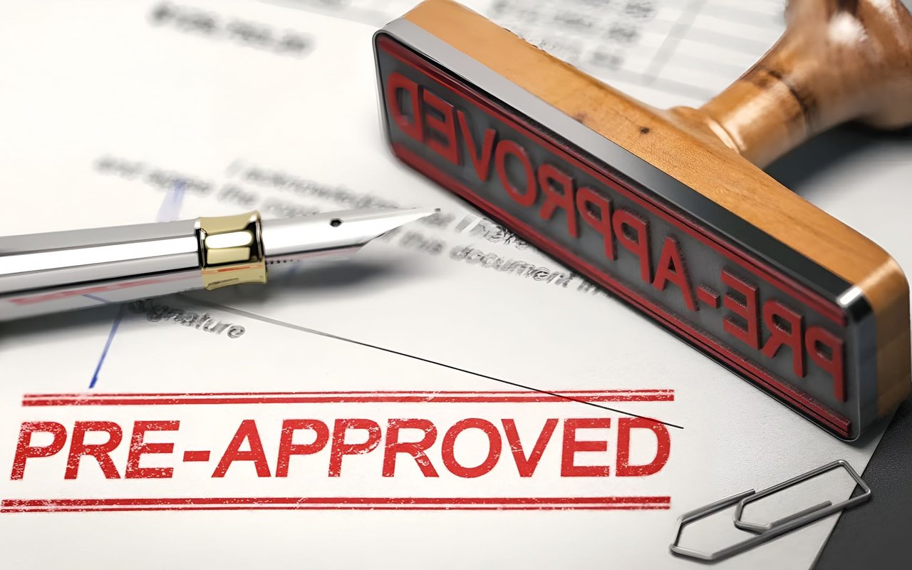 Mortgage paperwork stamped “PRE-APPROVED” beside a silver pen and paper clip.