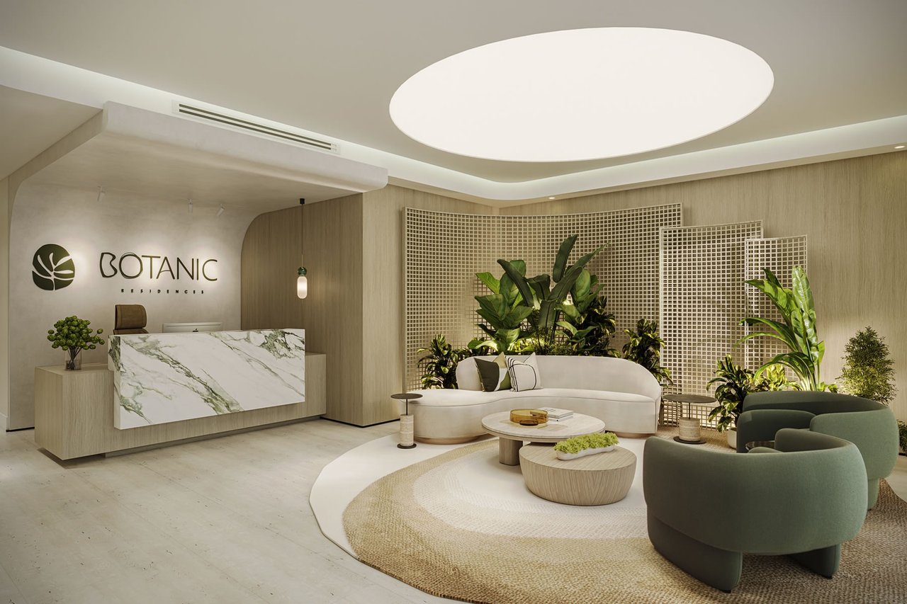 Botanic Residences lobby with a marble reception desk, curved seating, and indoor plants.