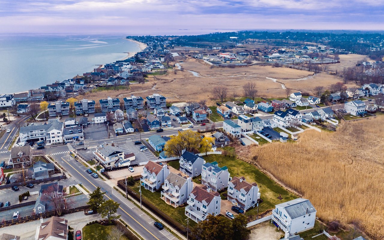 Aerial view of Fairfield’s coastal neighborhood, with shoreline homes beside marshland and the water.