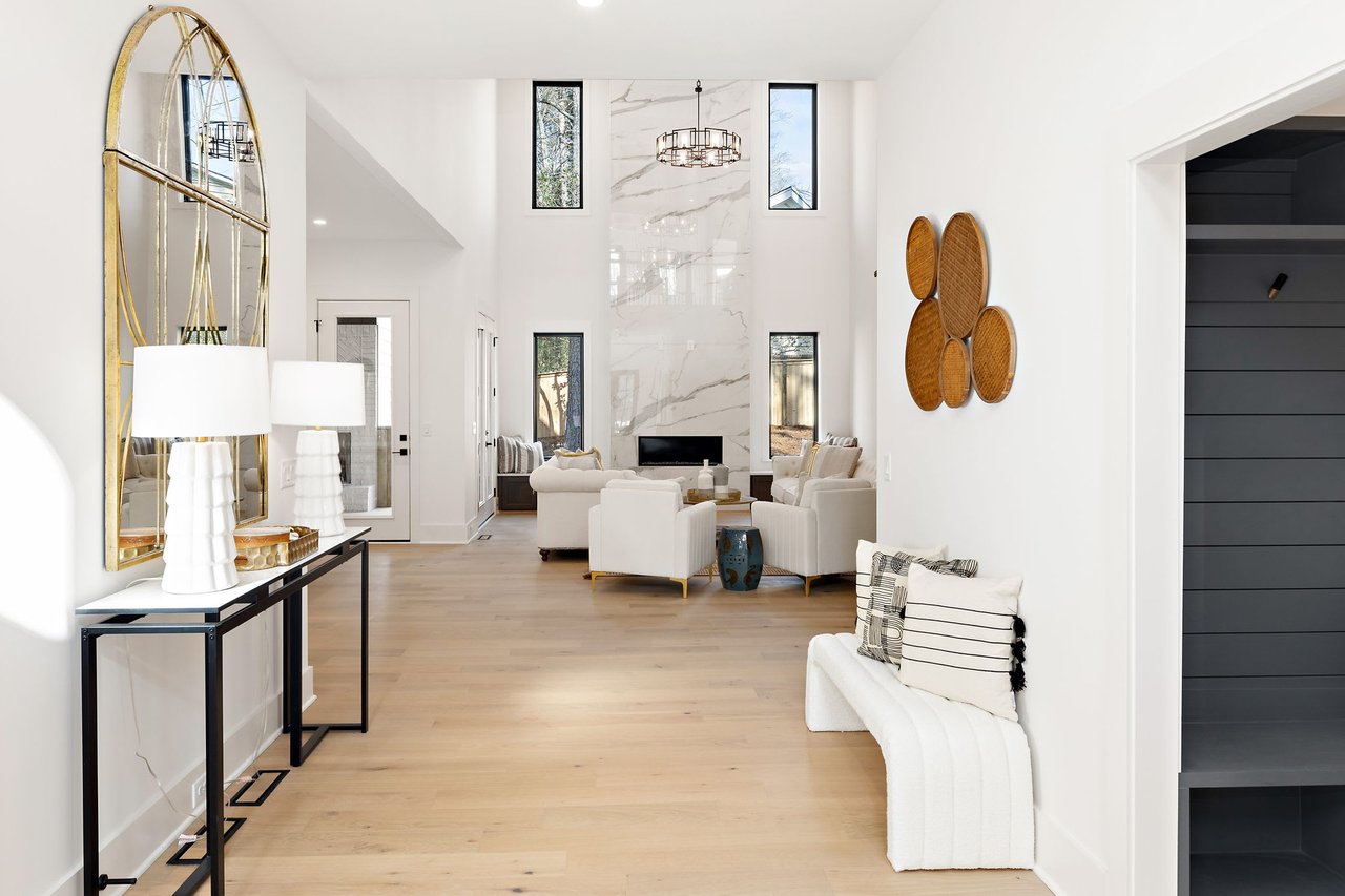 Stunning area leading to the great room in Ridgewater Bleu luxury home, Marietta GA, showcasing a 20 ft fireplace with exotic tile and two large windows, blending elegance and architectural charm.