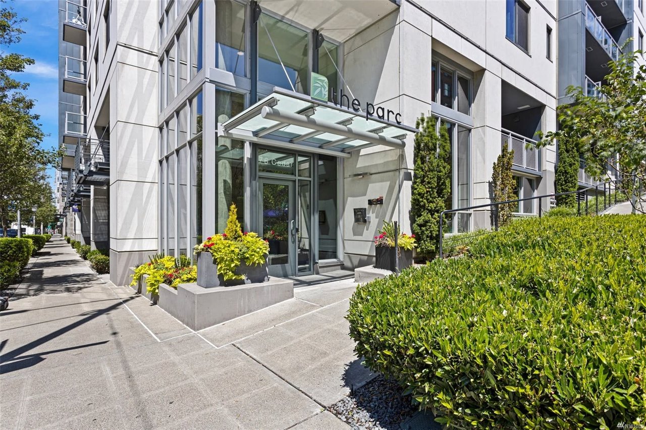 Entrance to The Parc condominium, a modern urban residence surrounded by well-kept greenery, welcoming luxury living.