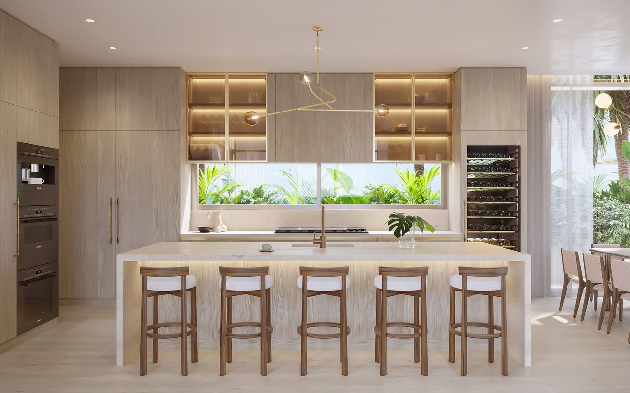 Luxury kitchen with a large island, five bar stools, illuminated cabinets, and tropical greenery outside