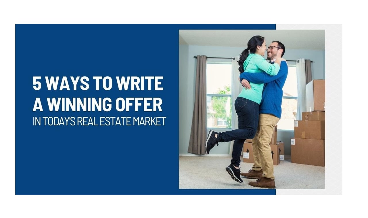 5 ways to write a winning offer in today's real estate market. Male and female embracing in a room with numerous moving boxes in the corner and in front of windows