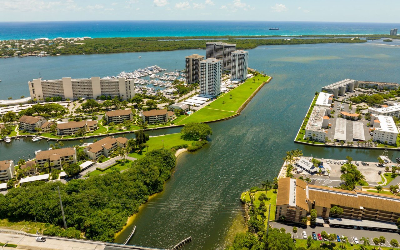 Aerial view of North Palm Beach waterfront condos, marina, inlet, and Atlantic coastline.
