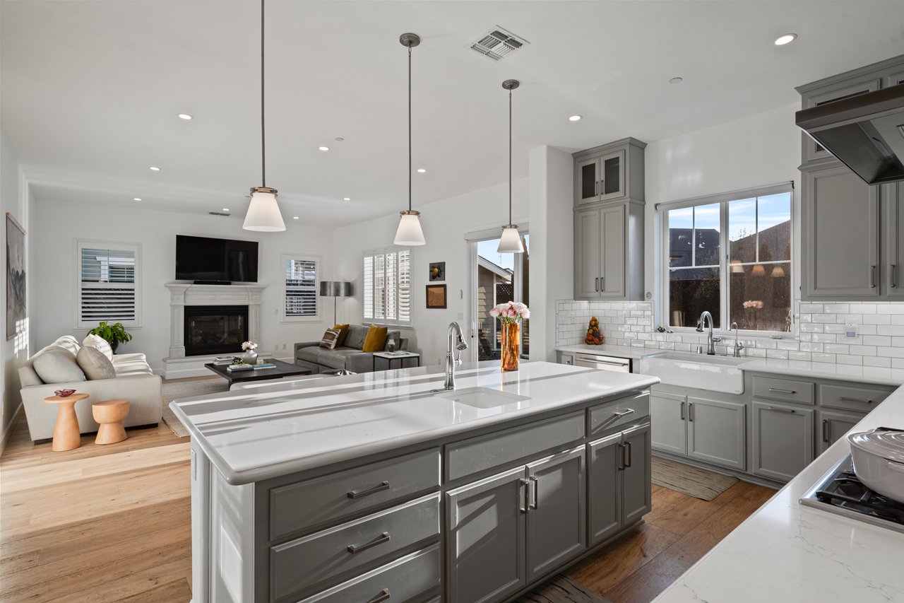 Kitchen featuring apron-front sink, tile backsplash, and prep bar