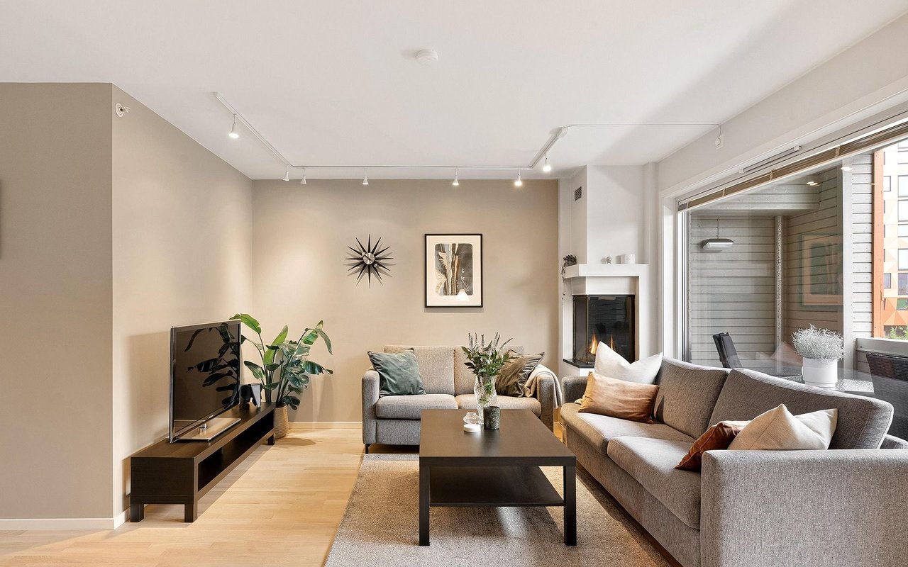 Living room with gray sofas, a fireplace, and sliding glass doors to a balcony.