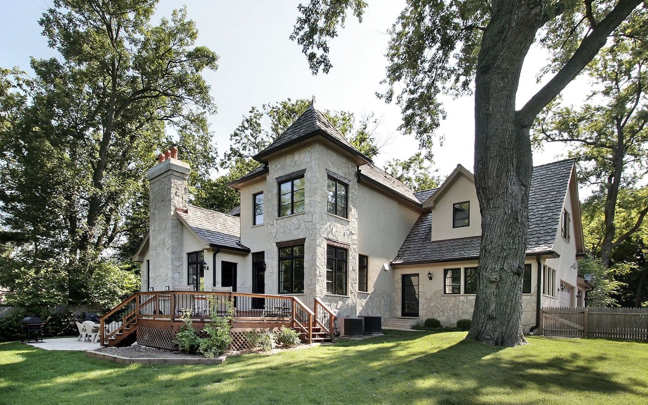 A cozy cottage-style house surrounded by a vibrant landscape