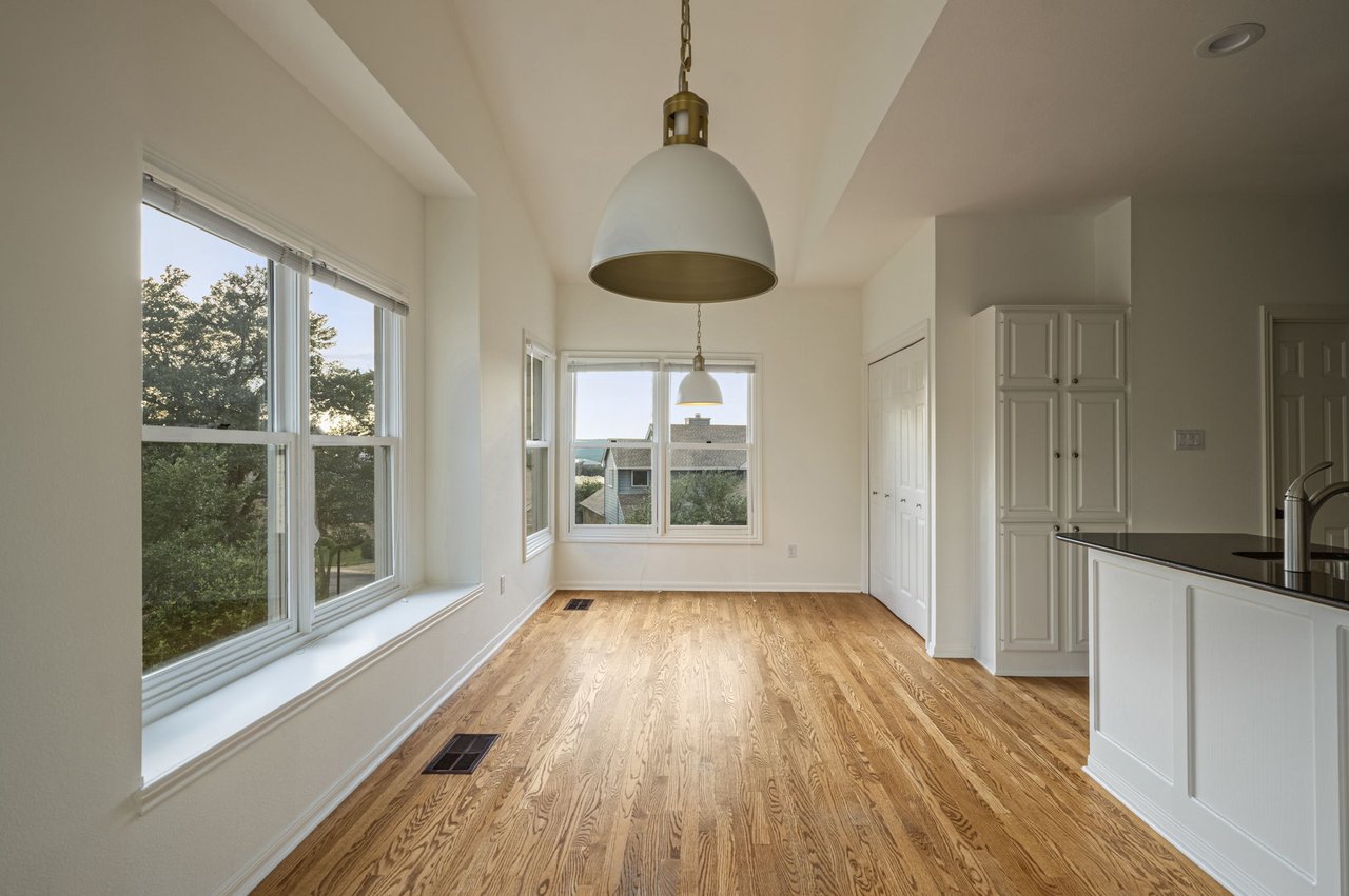 Dining area with brass pendant, oak floors and corner windows to the trees, Davenport Ranch townhome, Westlake.