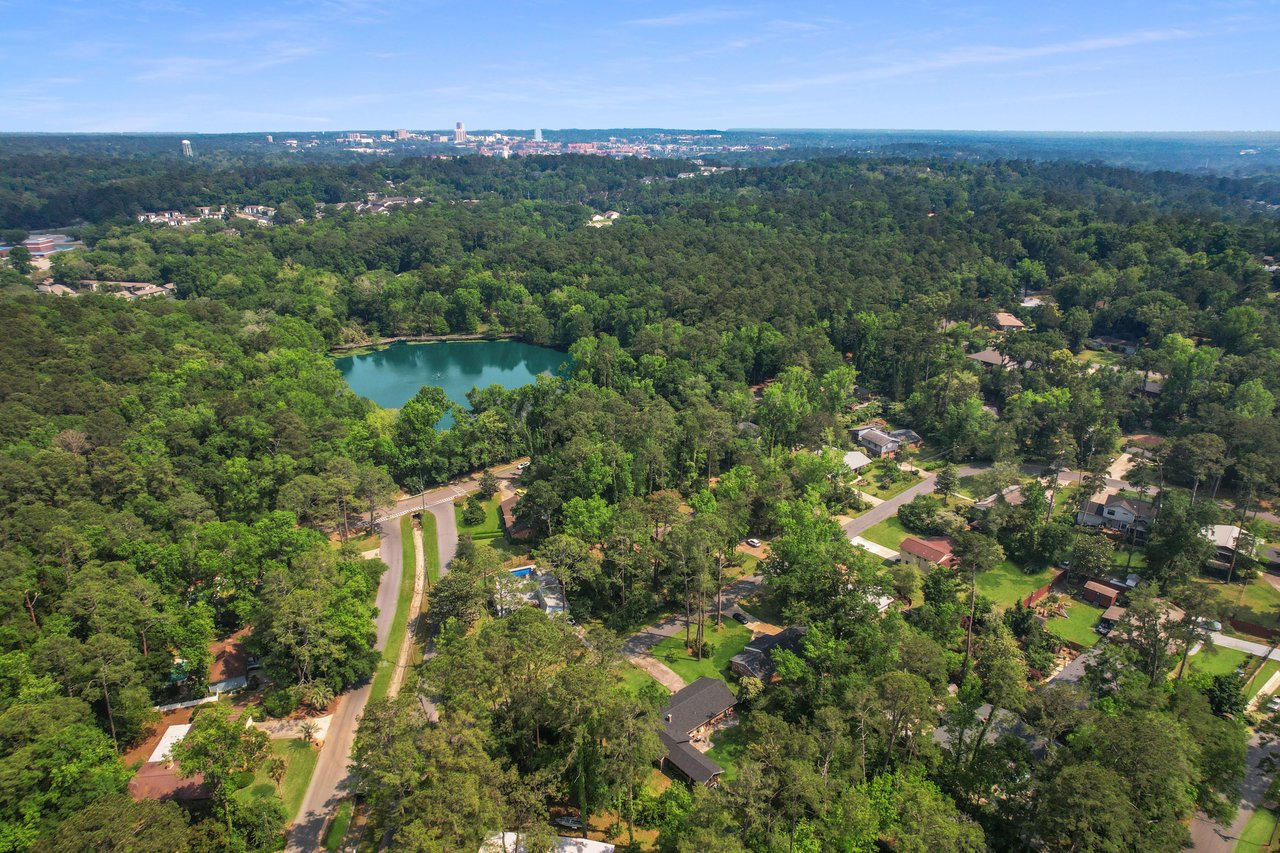 Another aerial view of San Luis, focusing on the layout of houses and streets around the lake. The community appears well-integrated with its natural surroundings.