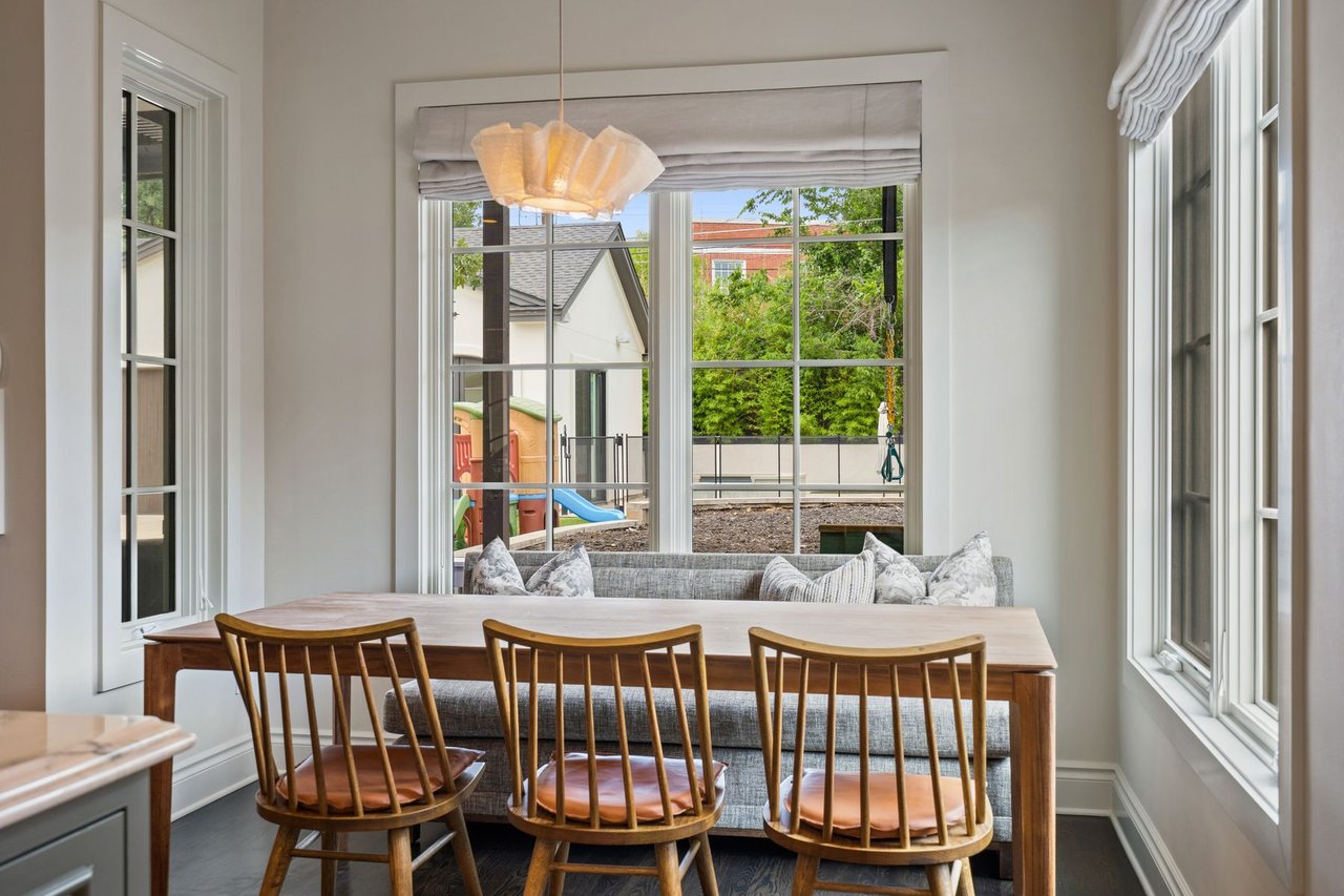 Breakfast nook with a wood dining table, spindle-back chairs, and a sculptural pendant light, furnished by Ashby Collective, at 2600 Westover Road in Tarrytown, Austin.