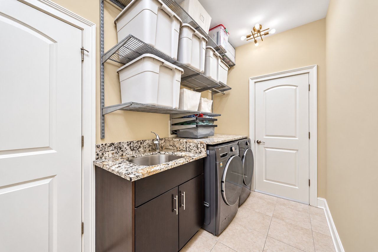 Separate laundry room with side-by-side washer and dryer and utility sink