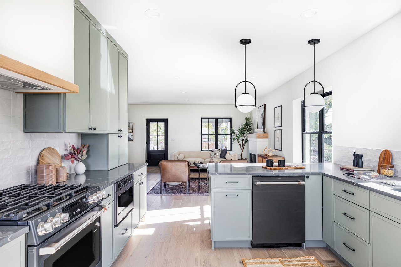 Front-facing view of bright kitchen into the living area showcasing state-of-the-art gas range