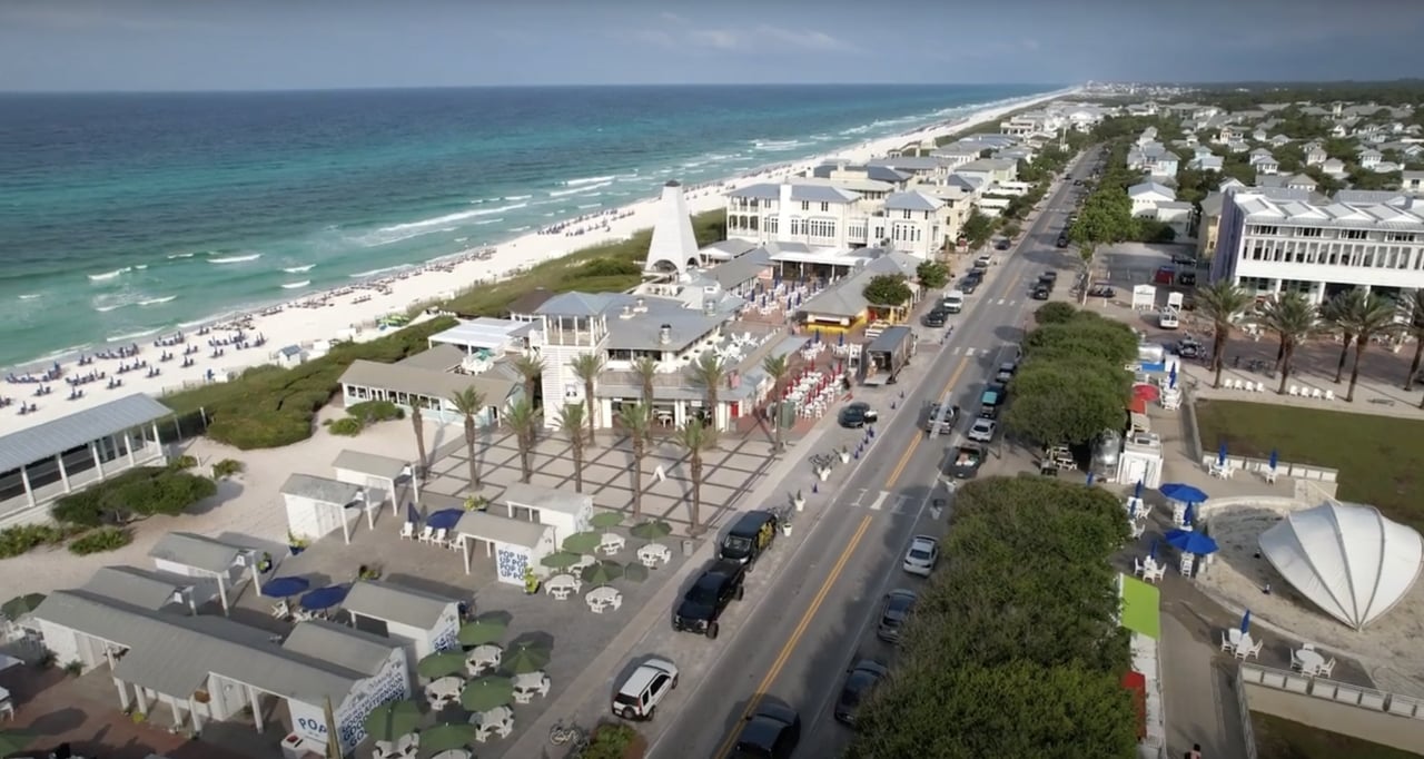 Aerial view of Seaside, Florida, with its Gulf beach, coastal buildings, and main road.
