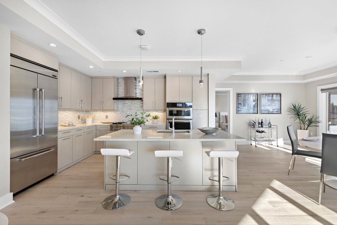 Spacious kitchen with a sleek island, modern lighting, and stainless steel appliances